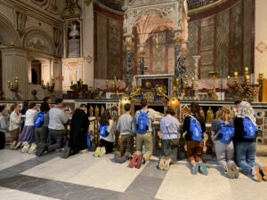 Fr John Paul and Chesterson students praying before the alter of St Cecilia, Rome 2024